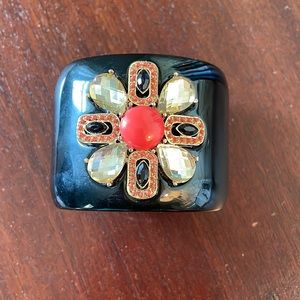 Stella and dot black cuff bracelet with a jewel flower on top.